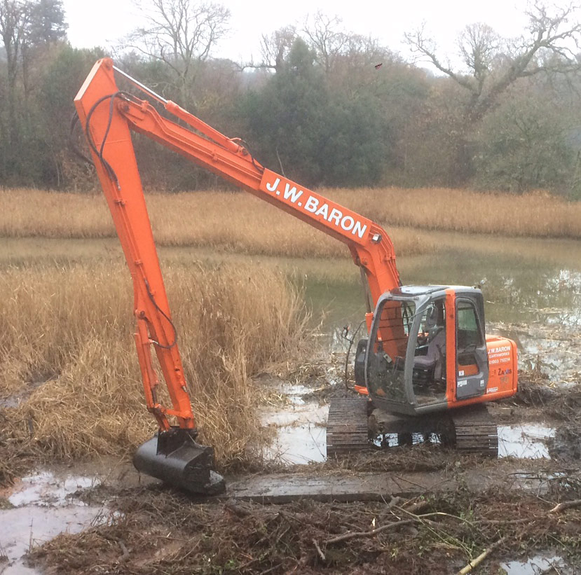 A Long Reach Excavator dredging a lake in Devon